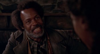 Movie still from “Beloved” (1998), directed by Jonathan Demme – An older black man smiling and looking at the camera; Close Up shot, Over the shoulder angle
