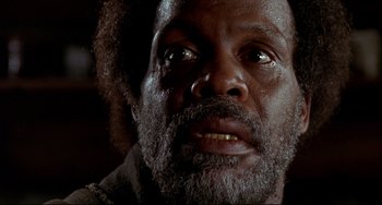 Movie still from “Beloved” (1998), directed by Jonathan Demme – An old man with a beard and a mustache looking at the camera; Close Up shot, Low angle