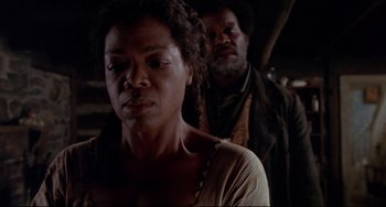 Movie still from “Beloved” (1998), directed by Jonathan Demme – A man and a woman standing next to each other in front of a building; Close Up shot, Over the shoulder angle