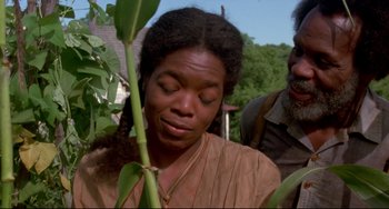 Movie still from “Beloved” (1998), directed by Jonathan Demme – An african - american woman looking down at a plant; Close Up shot, Over the shoulder angle