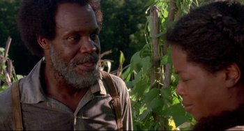 Movie still from “Beloved” (1998), directed by Jonathan Demme – A man and a woman standing next to each other in a field; Close Up shot, Over the shoulder angle