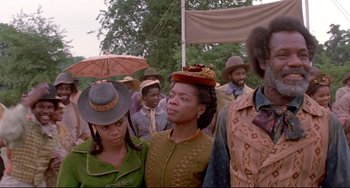 Movie still from “Beloved” (1998), directed by Jonathan Demme – A group of people standing next to each other holding umbrellas; Medium shot, Low angle