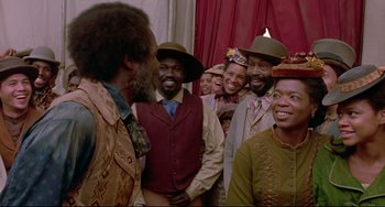 Movie still from “Beloved” (1998), directed by Jonathan Demme – A group of men and women standing next to each other; Medium shot, Over the shoulder angle