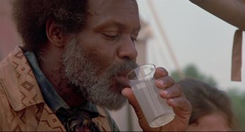 Movie still from “Beloved” (1998), directed by Jonathan Demme – An older man drinking a glass of water outside; Close Up shot, Low angle