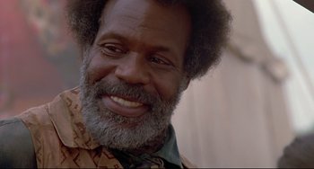 Movie still from “Beloved” (1998), directed by Jonathan Demme – A person with a beard smiling; Close Up shot, Low angle