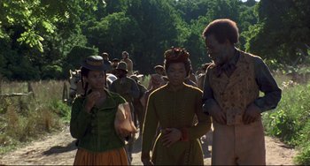 Movie still from “Beloved” (1998), directed by Jonathan Demme – A group of people walking down a street; Medium shot, Over the shoulder angle