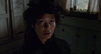 Movie still from “Beloved” (1998), directed by Jonathan Demme – A woman in a black dress and a black hat; Close Up shot, Low angle