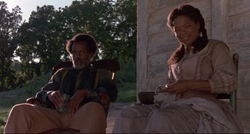 Movie still from “Beloved” (1998), directed by Jonathan Demme – A man and a woman sitting on a porch; Medium shot, Low angle