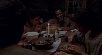 Movie still from “Beloved” (1998), directed by Jonathan Demme – A group of people sitting around a table eating food; Medium shot, High angle