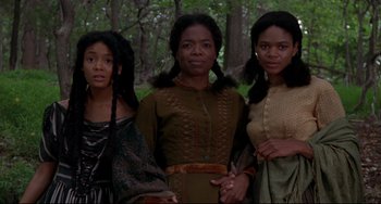 Movie still from “Beloved” (1998), directed by Jonathan Demme – A group of women standing next to each other in front of a forest; Medium shot, Low angle
