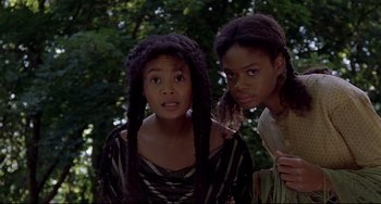 Movie still from “Beloved” (1998), directed by Jonathan Demme – Two young girls posing for a picture in front of a tree; Close Up shot, Low angle