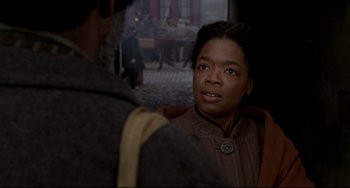 Movie still from “Beloved” (1998), directed by Jonathan Demme – A woman is looking at a man in the background; Close Up shot, Over the shoulder angle