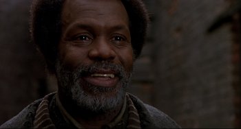 Movie still from “Beloved” (1998), directed by Jonathan Demme – An older man smiling for the camera; Close Up shot, Low angle