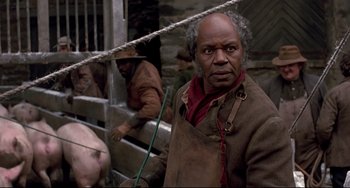 Movie still from “Beloved” (1998), directed by Jonathan Demme – An older man standing in front of a wooden fence; Close Up shot, Over the shoulder angle