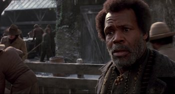 Movie still from “Beloved” (1998), directed by Jonathan Demme – An older man with a beard is looking at the camera; Close Up shot, Over the shoulder angle