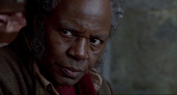 Movie still from “Beloved” (1998), directed by Jonathan Demme – An older man with a beard and a red scarf; Close Up shot, Low angle