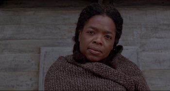 Movie still from “Beloved” (1998), directed by Jonathan Demme – A woman wrapped in a blanket looking at the camera; Close Up shot, Low angle