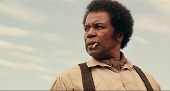 Movie still from “Beloved” (1998), directed by Jonathan Demme – A man with a beard is smoking a cigarette; Close Up shot, Low angle