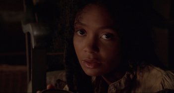 Movie still from “Beloved” (1998), directed by Jonathan Demme – A young person with a dark background; Close Up shot, Over the shoulder angle