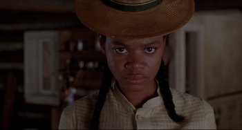 Movie still from “Beloved” (1998), directed by Jonathan Demme – A young girl wearing a hat and braids; Close Up shot, Low angle