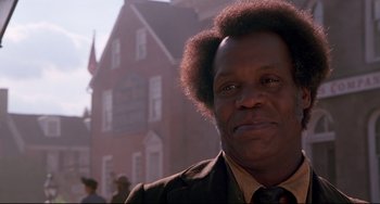 Movie still from “Beloved” (1998), directed by Jonathan Demme – A person wearing a suit and tie; Close Up shot, Low angle