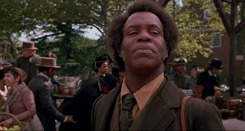 Movie still from “Beloved” (1998), directed by Jonathan Demme – A person wearing a suit and tie; Close Up shot, Low angle