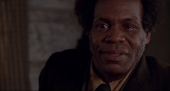 Movie still from “Beloved” (1998), directed by Jonathan Demme – A man with a black jacket and a brown tie; Close Up shot, Low angle