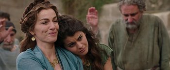 Movie still from “Ben-Hur” (2016), directed by Timur Bekmambetov – A woman is hugging a woman while another woman looks on; Close Up shot, Over the shoulder angle