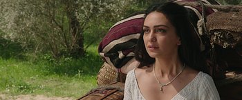 Movie still from “Ben-Hur” (2016), directed by Timur Bekmambetov – A woman in a white dress sitting in front of a tree; Close Up shot, Over the shoulder angle