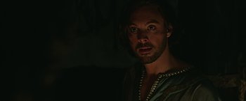 Movie still from “Ben-Hur” (2016), directed by Timur Bekmambetov – A man with long hair and a beard stares at the camera; Close Up shot, Over the shoulder angle