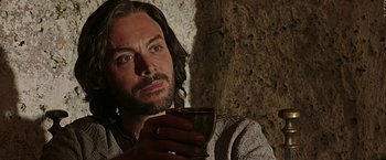 Movie still from “Ben-Hur” (2016), directed by Timur Bekmambetov – A man with long hair holding a cup of coffee; Close Up shot, Over the shoulder angle