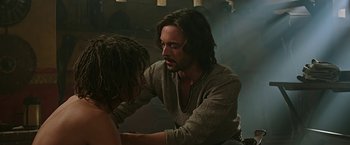 Movie still from “Ben-Hur” (2016), directed by Timur Bekmambetov – A man sitting on the ground with a woman; Medium shot, Over the shoulder angle