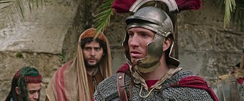 Movie still from “Ben-Hur” (2016), directed by Timur Bekmambetov – A man in a roman soldier's helmet stands next to a man in a roman soldier's costume; Close Up shot, Over the shoulder angle
