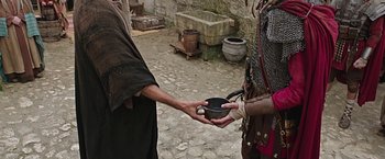 Movie still from “Ben-Hur” (2016), directed by Timur Bekmambetov – Two people are holding a bowl in their hands; Medium shot, High angle