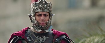 Movie still from “Ben-Hur” (2016), directed by Timur Bekmambetov – A man in a roman soldier's helmet and armor; Close Up shot, Low angle