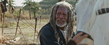 Movie still from “Ben-Hur” (2016), directed by Timur Bekmambetov – An older man with dreads is sitting outside; Close Up shot, Over the shoulder angle