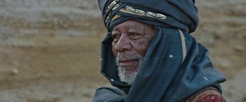 Movie still from “Ben-Hur” (2016), directed by Timur Bekmambetov – An older man with a beard and a head covering; Close Up shot, Over the shoulder angle