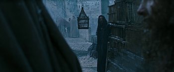 Movie still from “Ben-Hur” (2016), directed by Timur Bekmambetov – A man with a long beard standing next to a building; Medium shot, Low angle