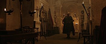 Movie still from “Ben-Hur” (2016), directed by Timur Bekmambetov – A man dressed as a roman soldier in a room full of weapons; Wide shot, Low angle