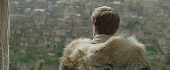 Movie still from “Ben-Hur” (2016), directed by Timur Bekmambetov – A man wearing a fur coat looking out a window; Close Up shot, Low angle