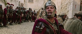 Movie still from “Ben-Hur” (2016), directed by Timur Bekmambetov – A man in a roman soldier's outfit with other roman soldiers in the background; Medium shot, Low angle