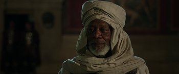 Movie still from “Ben-Hur” (2016), directed by Timur Bekmambetov – An older man wearing a head covering and a turban; Close Up shot, Over the shoulder angle