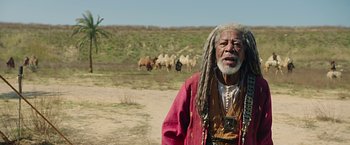 Movie still from “Ben-Hur” (2016), directed by Timur Bekmambetov – An older man with dreadlocks and a long beard standing in front of a herd of cattle; Medium shot, Low angle