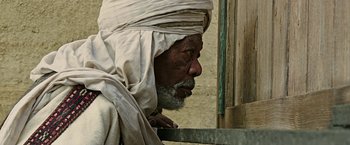 Movie still from “Ben-Hur” (2016), directed by Timur Bekmambetov – An old man with a beard and a turban on; Close Up shot, Over the shoulder angle