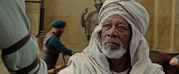 Movie still from “Ben-Hur” (2016), directed by Timur Bekmambetov – An old man with a beard and a turban is looking into the camera; Close Up shot, Over the shoulder angle