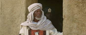 Movie still from “Ben-Hur” (2016), directed by Timur Bekmambetov – An older man wearing a white turban and a white robe; Medium shot, Low angle