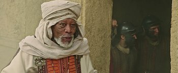 Movie still from “Ben-Hur” (2016), directed by Timur Bekmambetov – An old man wearing a turban is standing in front of a wall; Close Up shot, Low angle