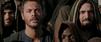 Movie still from “Ben-Hur” (2016), directed by Timur Bekmambetov – A person with a face covered in blood; Close Up shot, Over the shoulder angle