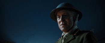An older man wearing a military uniform and a hat