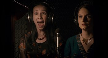 Two women are singing in a recording studio